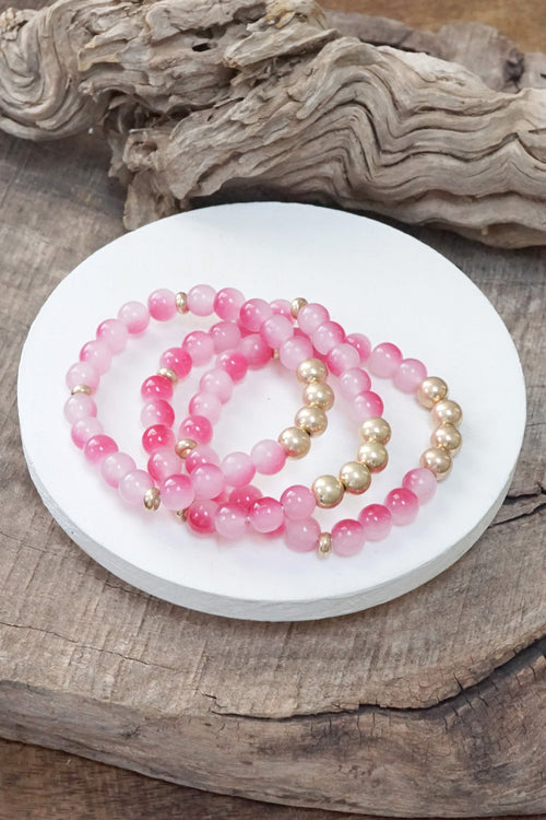 Worn gold tone and glass beads bracelets stack Hot Pink Blue Green