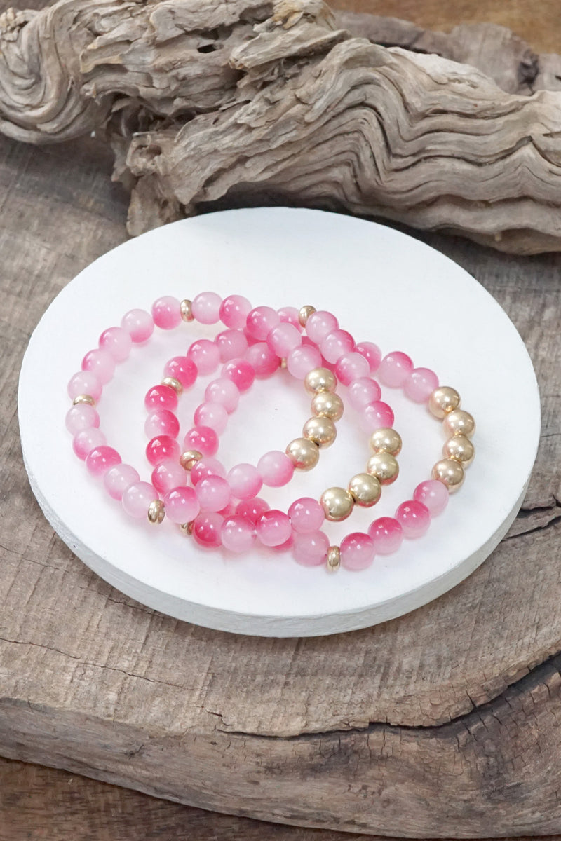 Worn gold tone and glass beads bracelets stack Hot Pink Blue Green
