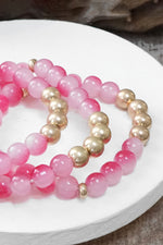 Worn gold tone and glass beads bracelets stack Hot Pink Blue Green