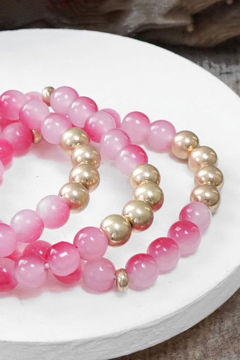 Worn gold tone and glass beads bracelets stack Hot Pink Blue Green
