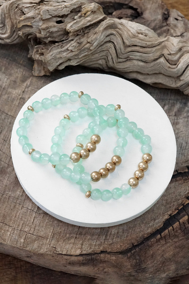 Worn gold tone and glass beads bracelets stack Hot Pink Blue Green
