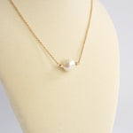 Short dainty necklace with a Pearl in gold tone