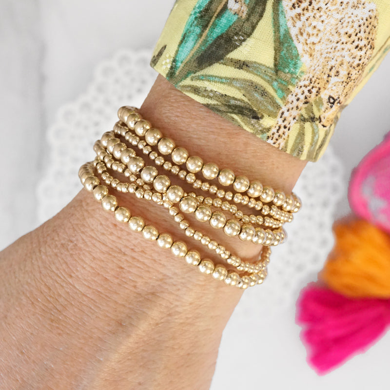 Worn Gold tone multi size beaded bracelet stack of 6 bracelets