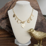 Multi-Charm Statement Necklace with Front Toggle & Heart Crystals – Gold Tone