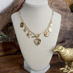 Multi-Charm Statement Necklace with Front Toggle & Heart Crystals – Gold Tone