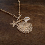 Front Toggle Multi-Charm Shell Statement Necklace – Gold Tone